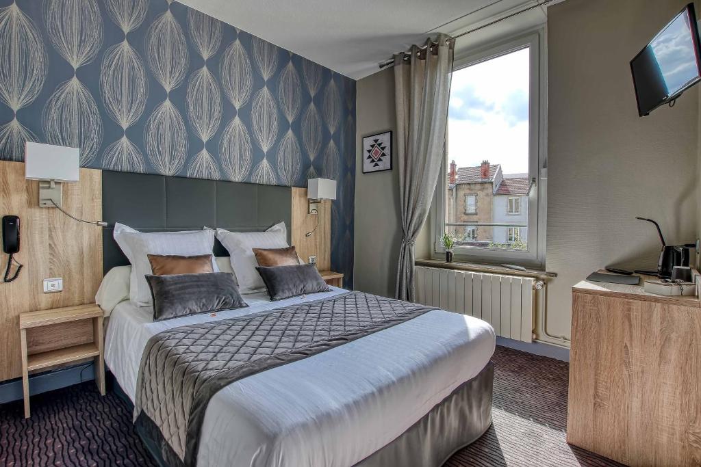 a hotel room with a large bed and a television at Cit'Hotel La Résidence in Nancy