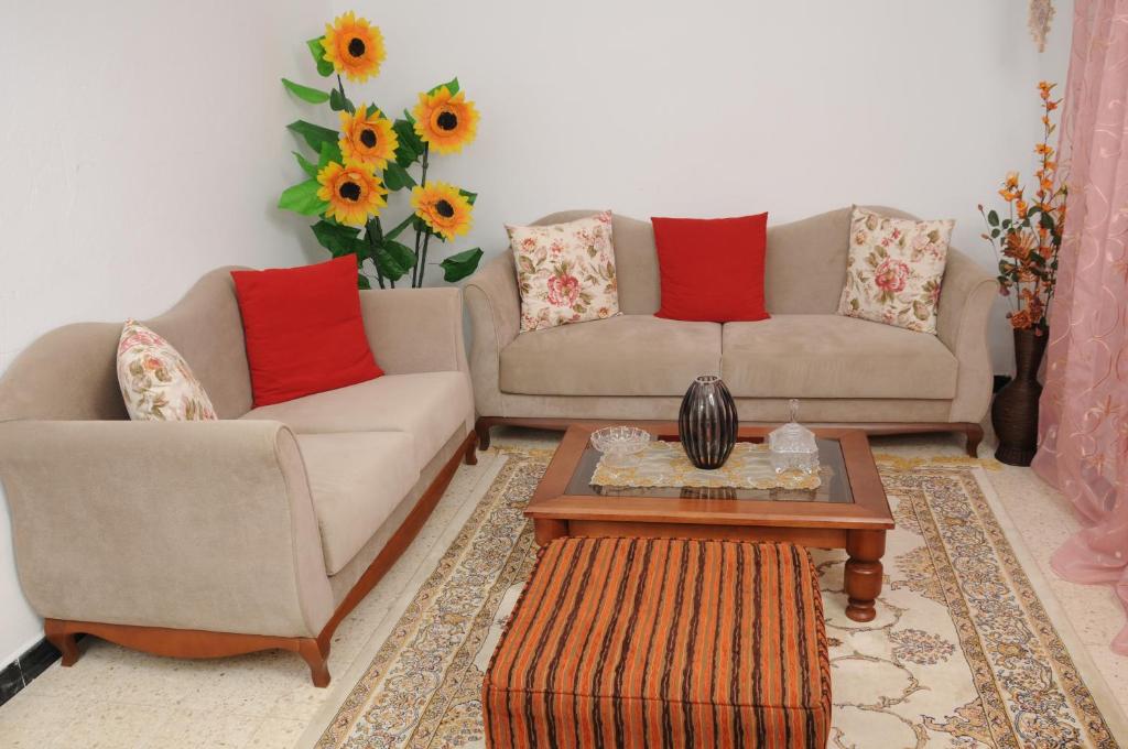 City Apartment Rades Tunis free Wifi في Radès: غرفة معيشة مع كنبتين وطاولة قهوة