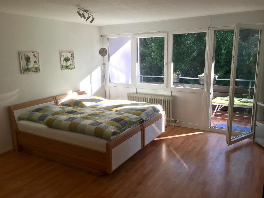 a bedroom with a bed in a room with windows at Ferienwohnung Asal in Waldbronn