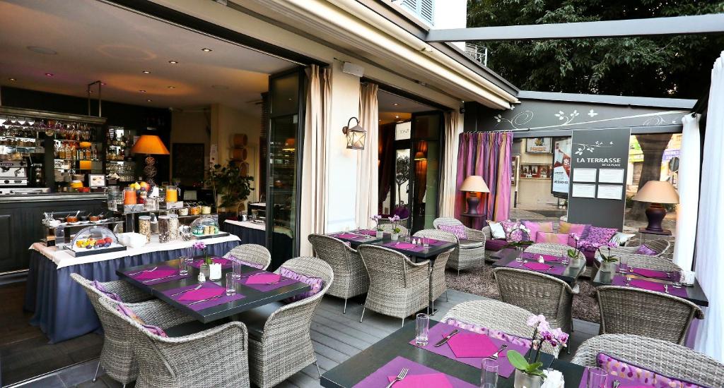 a restaurant with purple tables and chairs on a patio at La Place Boutique Hotel in Antibes