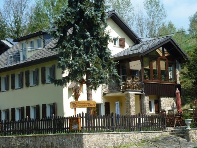 uma grande casa branca com uma cerca em frente em Fewo 1 em Freiberg