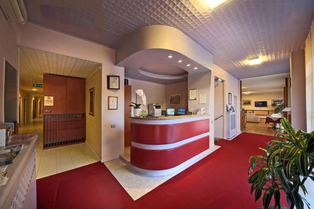 a restaurant lobby with a red and white counter at Hotel Cristallo Brescia in Brescia