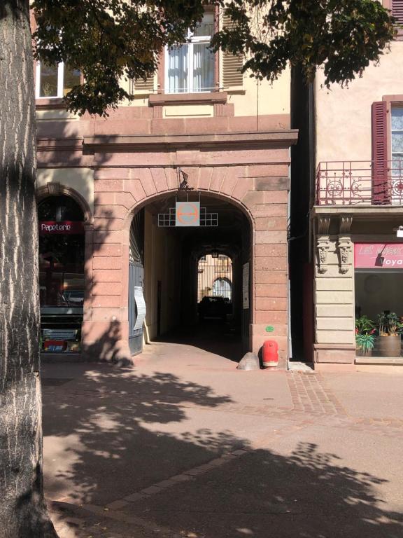 a building with an archway in the middle of a street at LE MUSCAT in Colmar