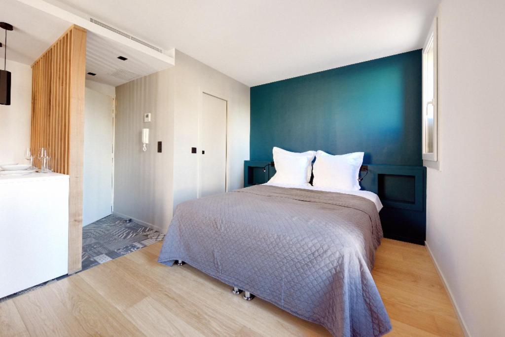 um quarto com uma cama grande e uma parede azul em Lou Cassiden - Magnifique appartement sur le Port em Cassis