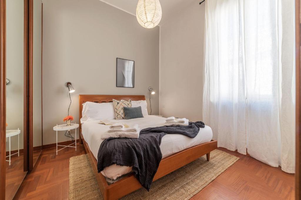 - une chambre avec un lit doté de draps blancs et une fenêtre dans l'établissement Lively Roma Trastevere renovated apartment - FromHometoRome, à Rome