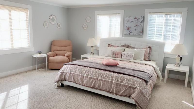 a white bedroom with a bed and a chair at Pasadena master room in Pasadena