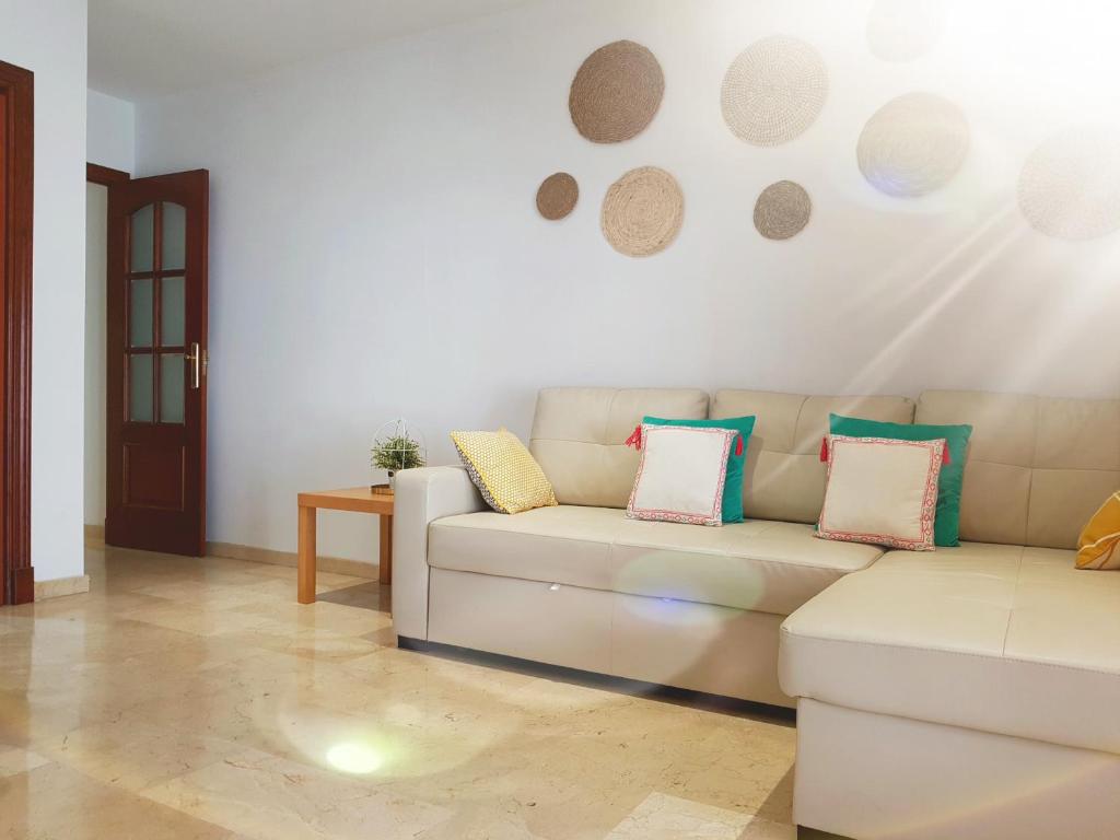 a living room with a couch with pillows on it at Bel appartement au centre ville et de la plage in Ceuta