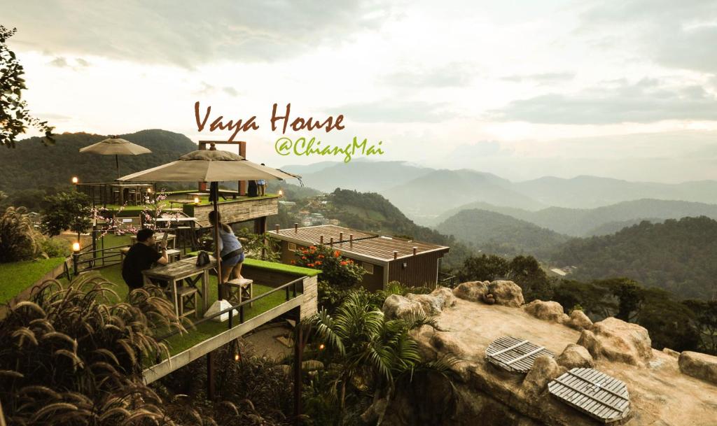a person sitting on a balcony of a house in the mountains at Vaya House in Chiang Mai