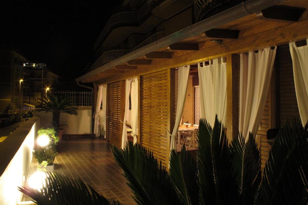 eine Terrasse am Abend mit einem Tisch und Vorhängen in der Unterkunft A casa di Andrea e Lucia in Gaeta