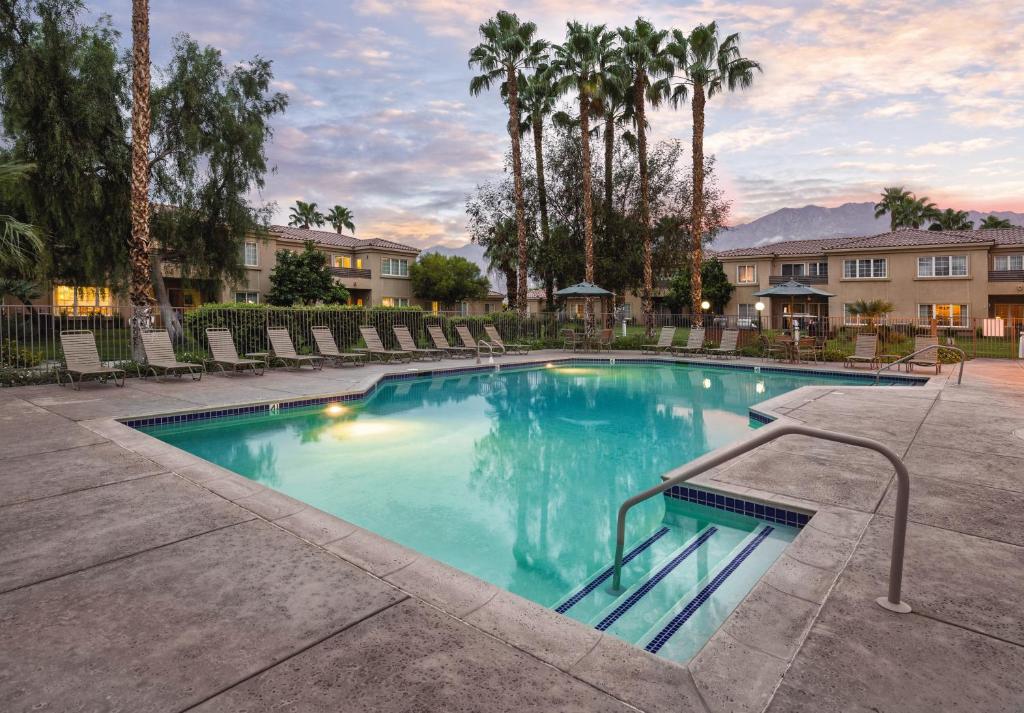 a large swimming pool with palm trees and buildings at WorldMark Cathedral City in Cathedral City