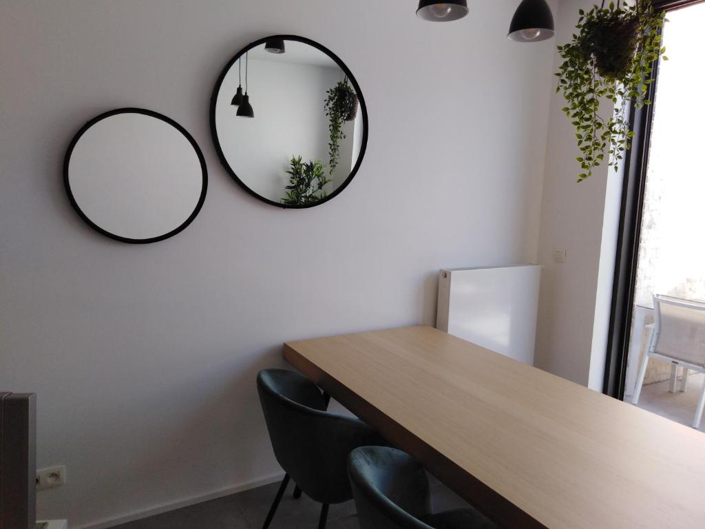 a dining room with a table and two mirrors on the wall at cosy@sea in Middelkerke