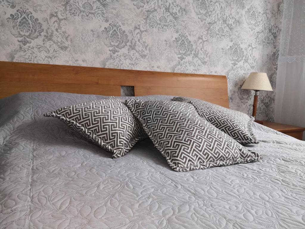 Una cama con dos almohadas encima. en Apartamentai ,,ASTRA'', en Birštonas