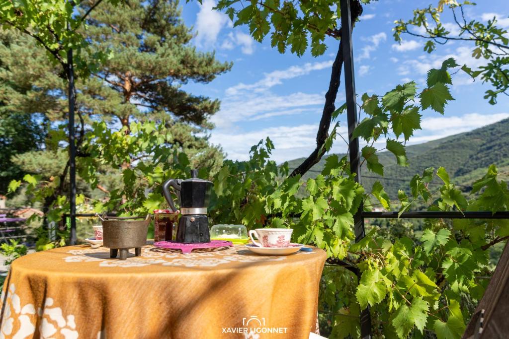 a table with a yellow table cloth on it with a view at Le Petit Paradis in Prémian