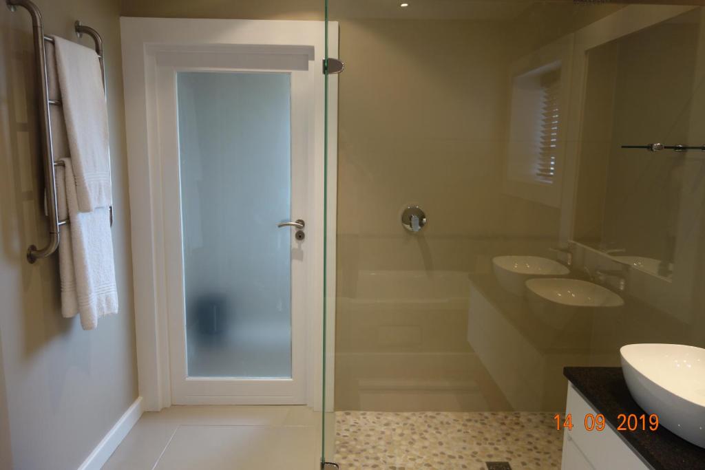 W łazience znajdują się 2 umywalki i przeszklony prysznic. w obiekcie Twin Rivers Villa w mieście Plettenberg Bay