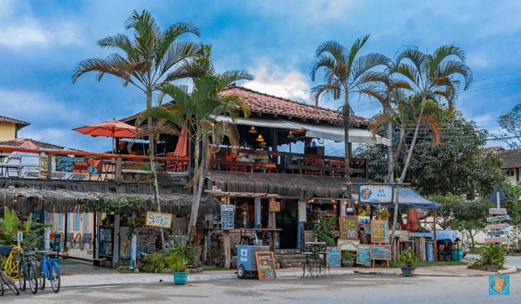 a restaurant with palm trees in front of a building at Hostel Sereia do Mar in Paraty