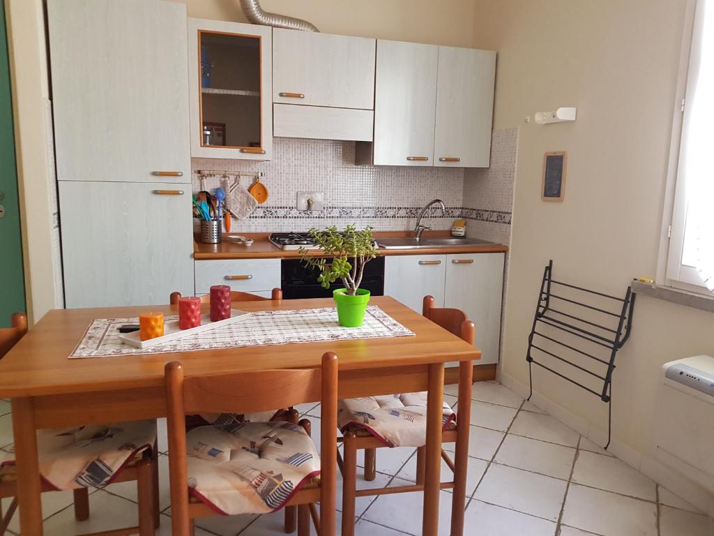 羅西尼亞諾蘇威的住宿－Appartamento Caletta，厨房配有木桌和桌椅