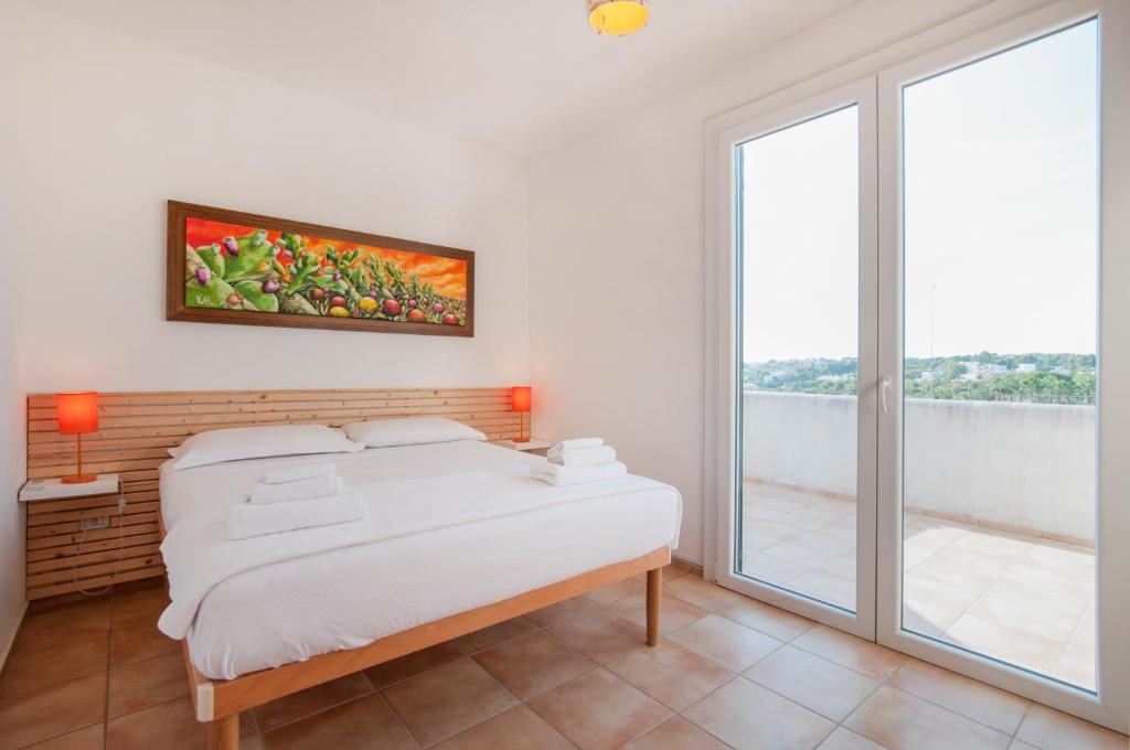 a white bedroom with a bed and a window at Residence Quattrocolonne in Santa Maria al Bagno