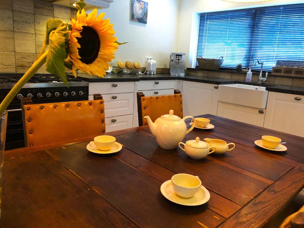 a kitchen with a wooden table with a sunflower at The Pelgrim House in Sint Jacobiparochie