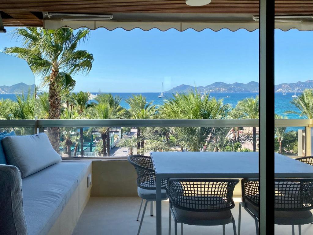 balcón con mesa, sillas y vistas al océano en Blvd De La Croisette 82A, Cannes, La Réale en Cannes