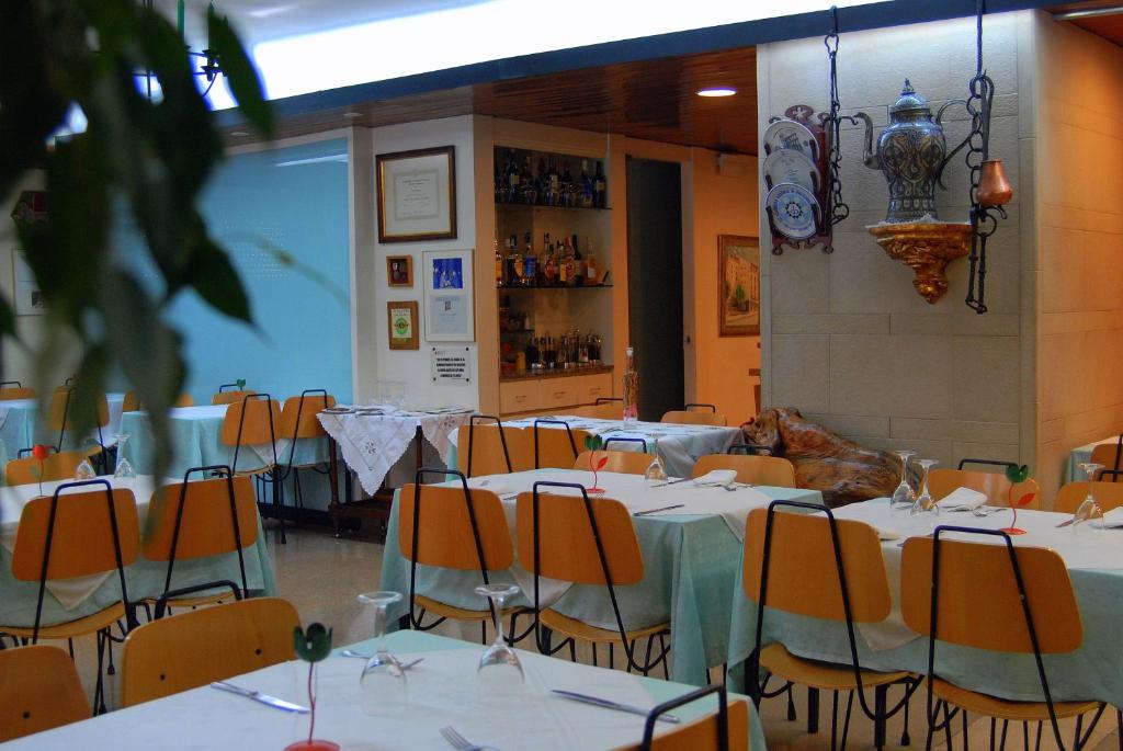 een eetkamer met tafels en stoelen en een ruimte met tafels en stoelen bij Hostal Victor in Oliana