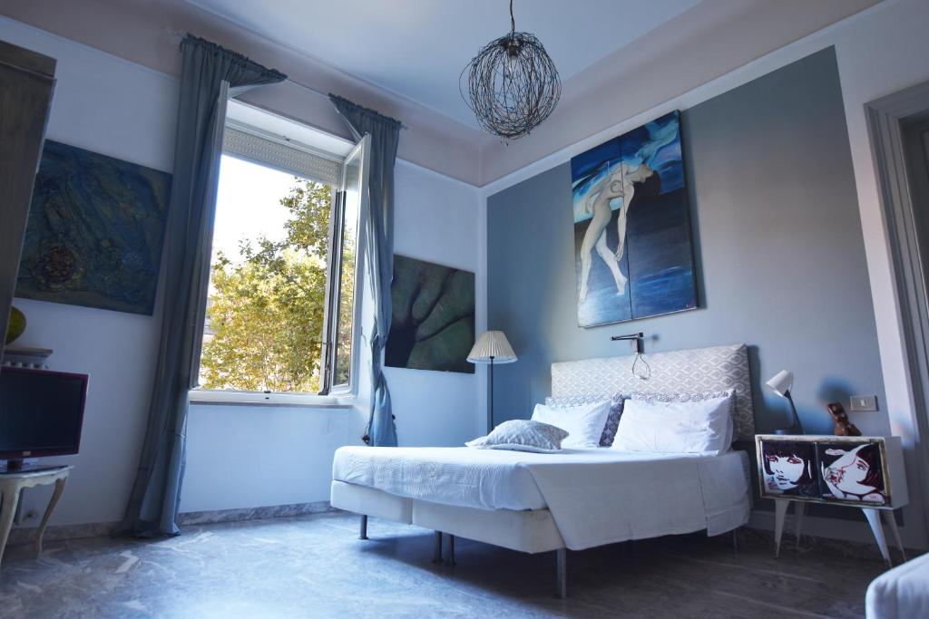 Dormitorio azul con cama y ventana en A Casa dell'Artista ViKi, en Iesi