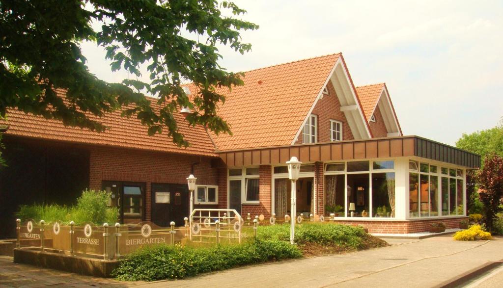 ein braunes Haus mit rotem Dach in der Unterkunft Landhotel Töns in Dülmen