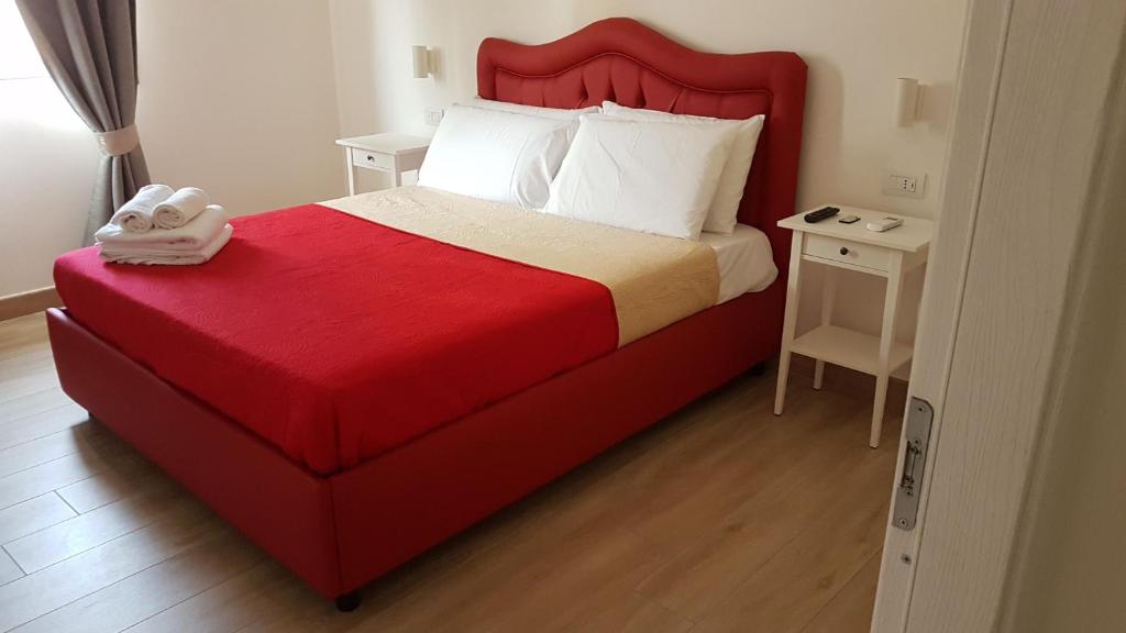 een rood bed met een rood hoofdeinde en een tafel bij B&B Pompeii Rooms in Pompei