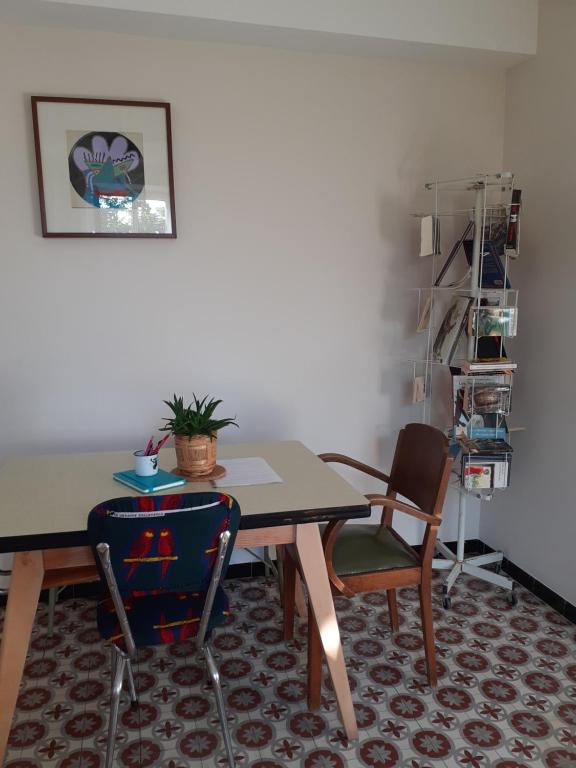 una mesa de comedor y sillas en una habitación en Le Nid de Jeanne en Lézignan-Corbières