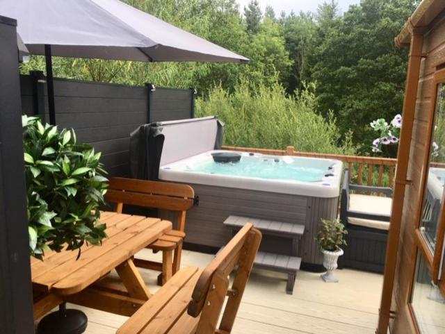 bañera de hidromasaje en una terraza con sombrilla en Logi - Bear, en Felton