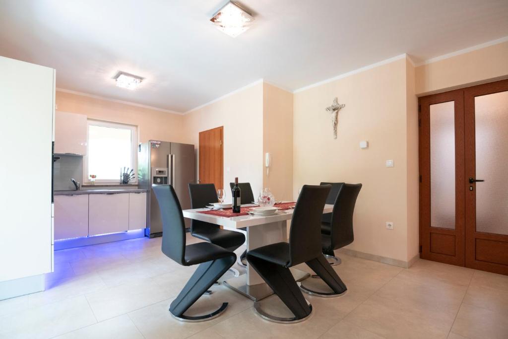 a dining room with a table and black chairs at Villa &quot;Mile&quot; in Katuni