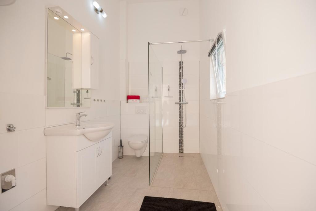 a white bathroom with a sink and a shower at Villa &quot;Mile&quot; in Katuni