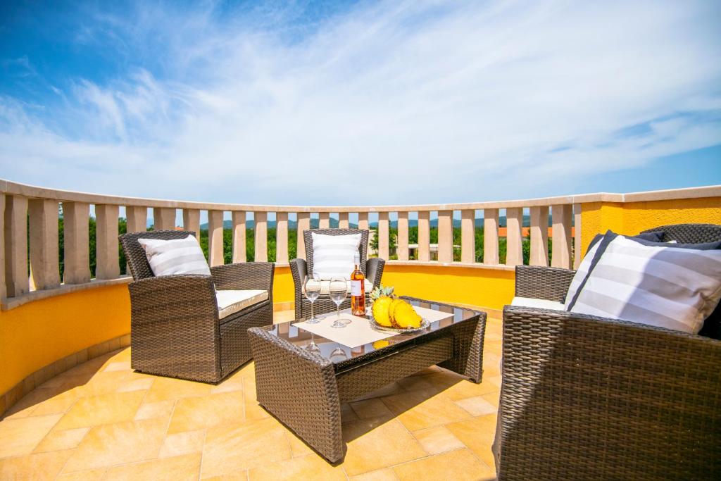 a patio with wicker chairs and a table on a balcony at Villa &quot;Mile&quot; in Katuni