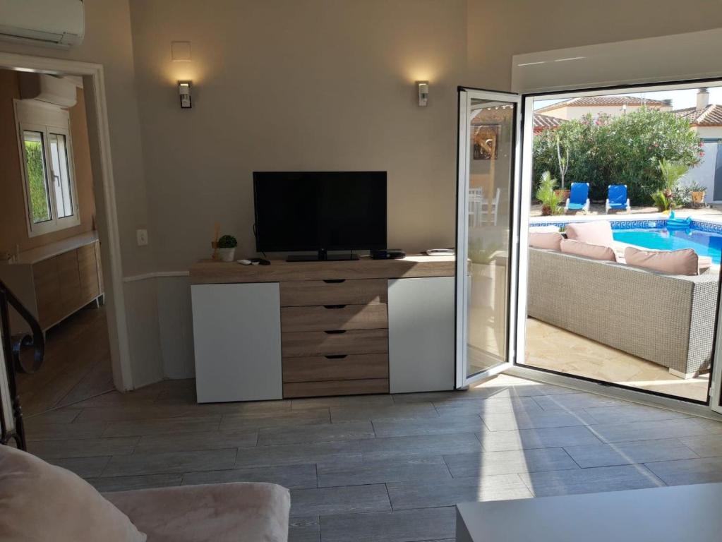 a living room with a television and a couch at Villa voor 8 personen met zwembad in Calafat