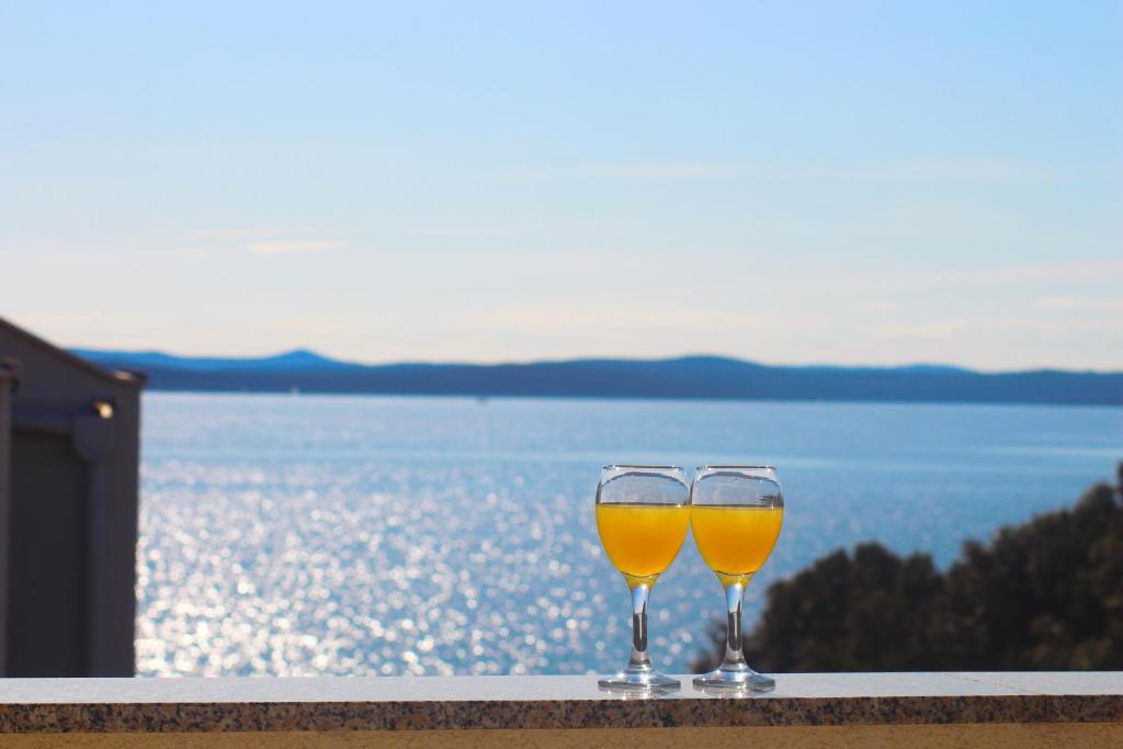 two glasses of wine sitting on a ledge overlooking the water at Villa Luna with Seaview in Petrcane