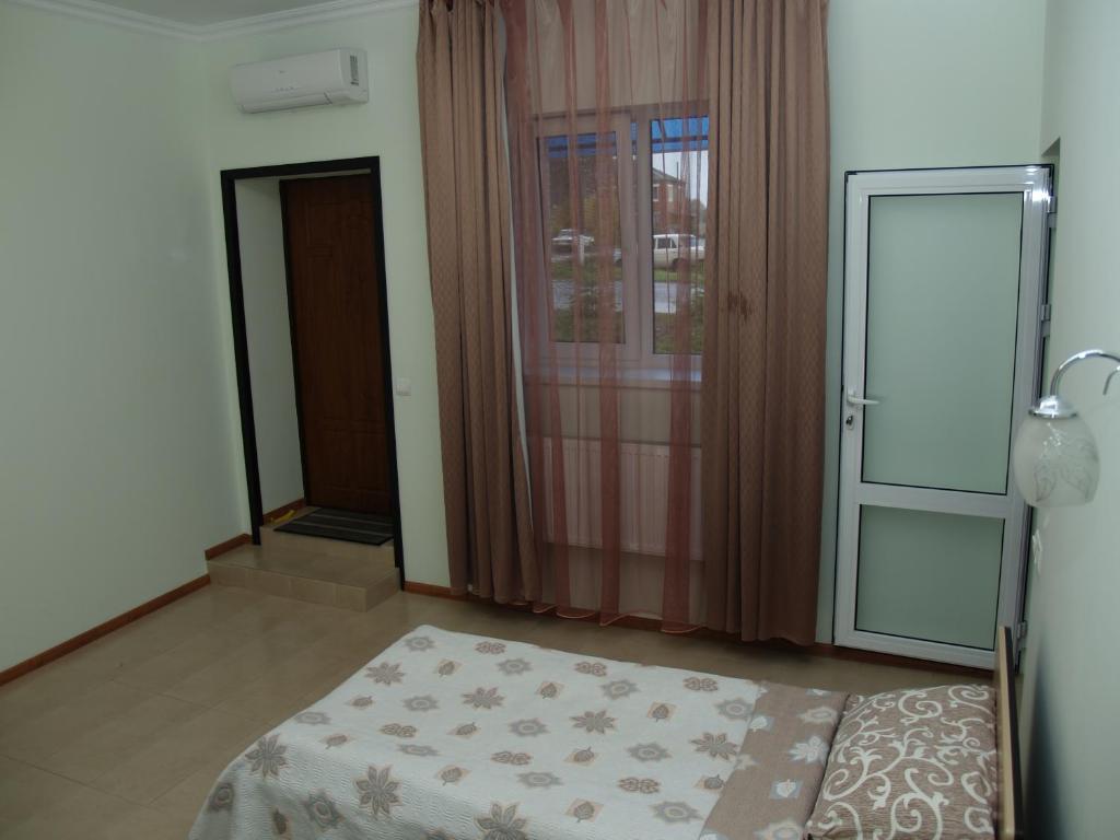 Habitación con cama y puerta con alfombra en Motel Sujet, en Bohodukhiv
