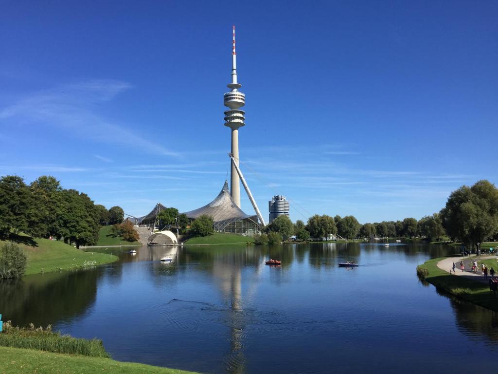 Studio München nahe Olympiapark في ميونخ: إطلالة على نهر مع برج تلفزيون في الخلفية