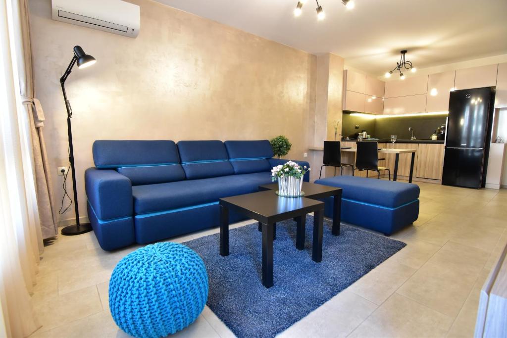 a living room with a blue couch and a table at Kapana Luxury City Center Apartments with Garage in Plovdiv