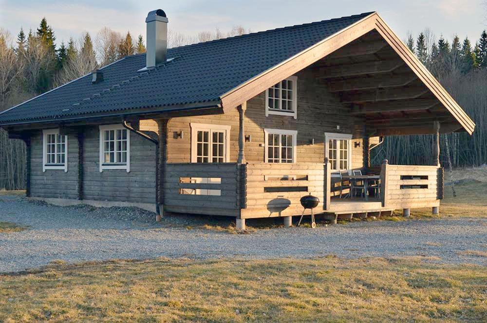 uma grande cabina de madeira com um telhado preto em Ferienhaus Stenbäcken in Mittelschweden em Töcksfors