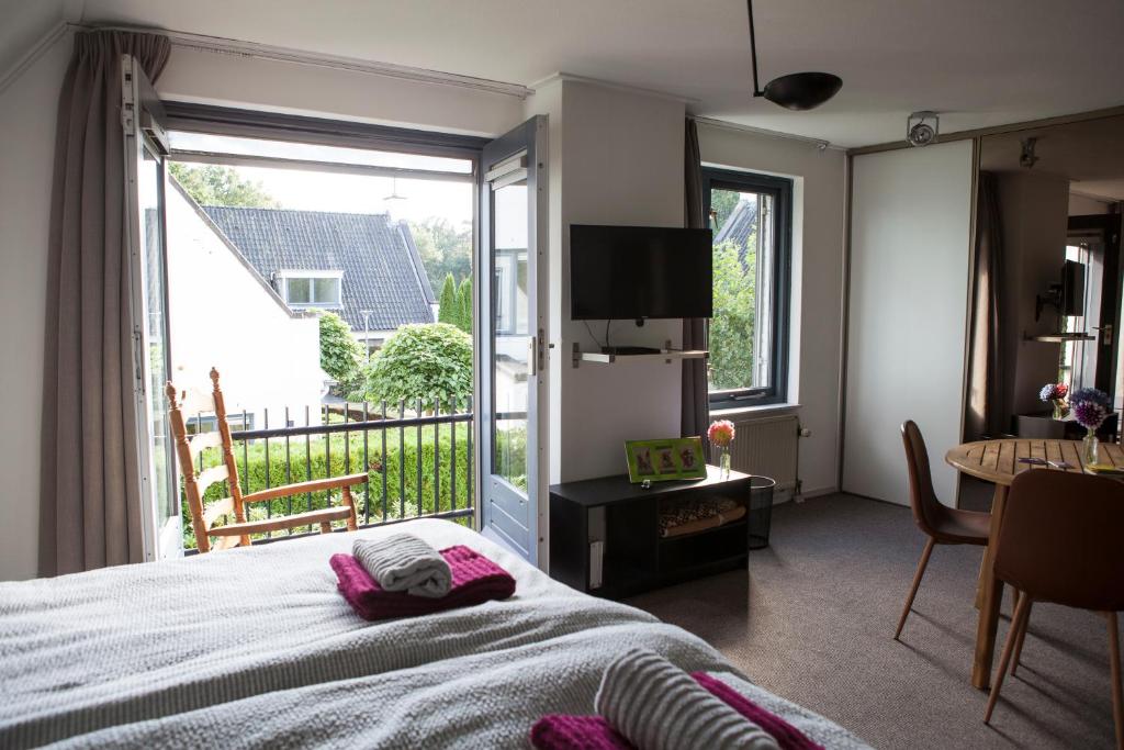 een slaapkamer met een bed en een groot raam bij De Heidestroper in Eindhoven