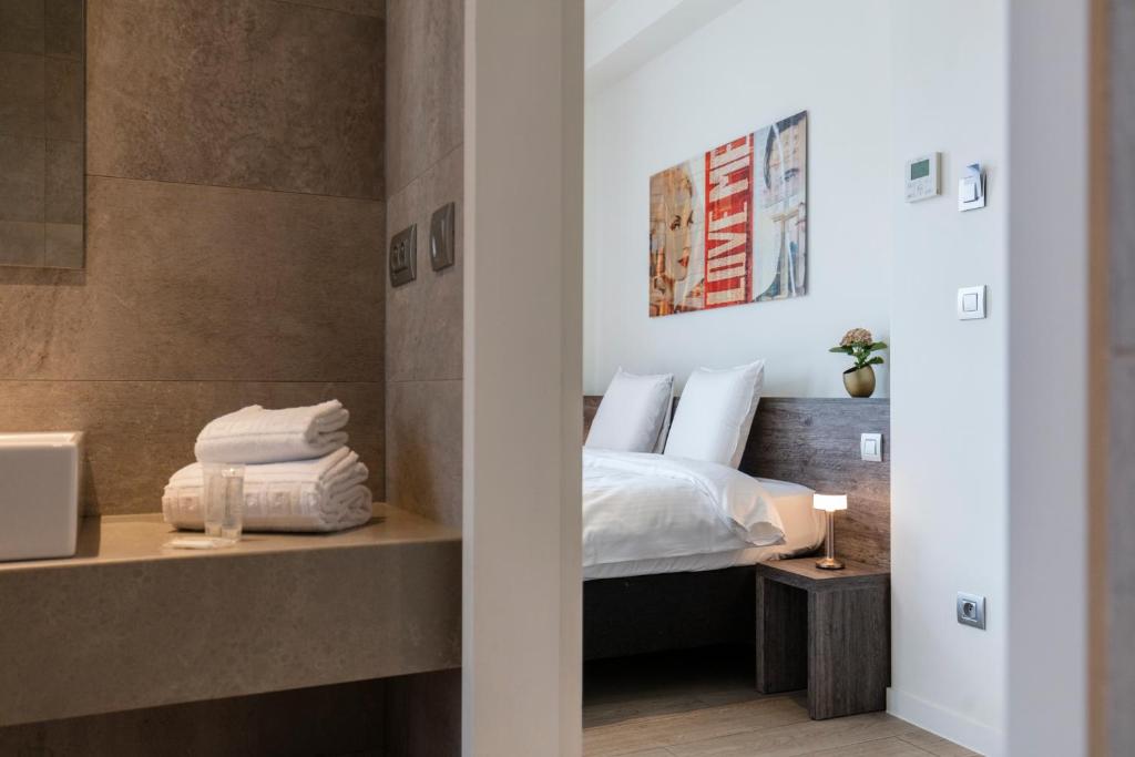 een slaapkamer met een bed met witte lakens en kussens bij The Market by Parkhotel in Kortrijk