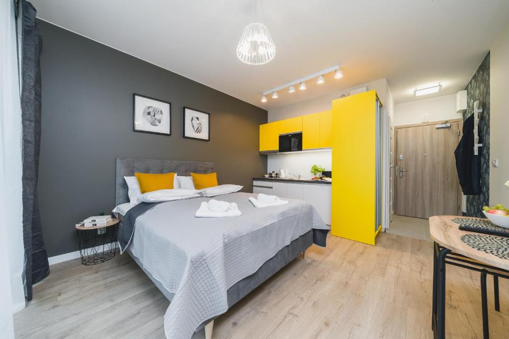 1 dormitorio con cama y pared amarilla en Sarah Apartments Old Town, en Cracovia