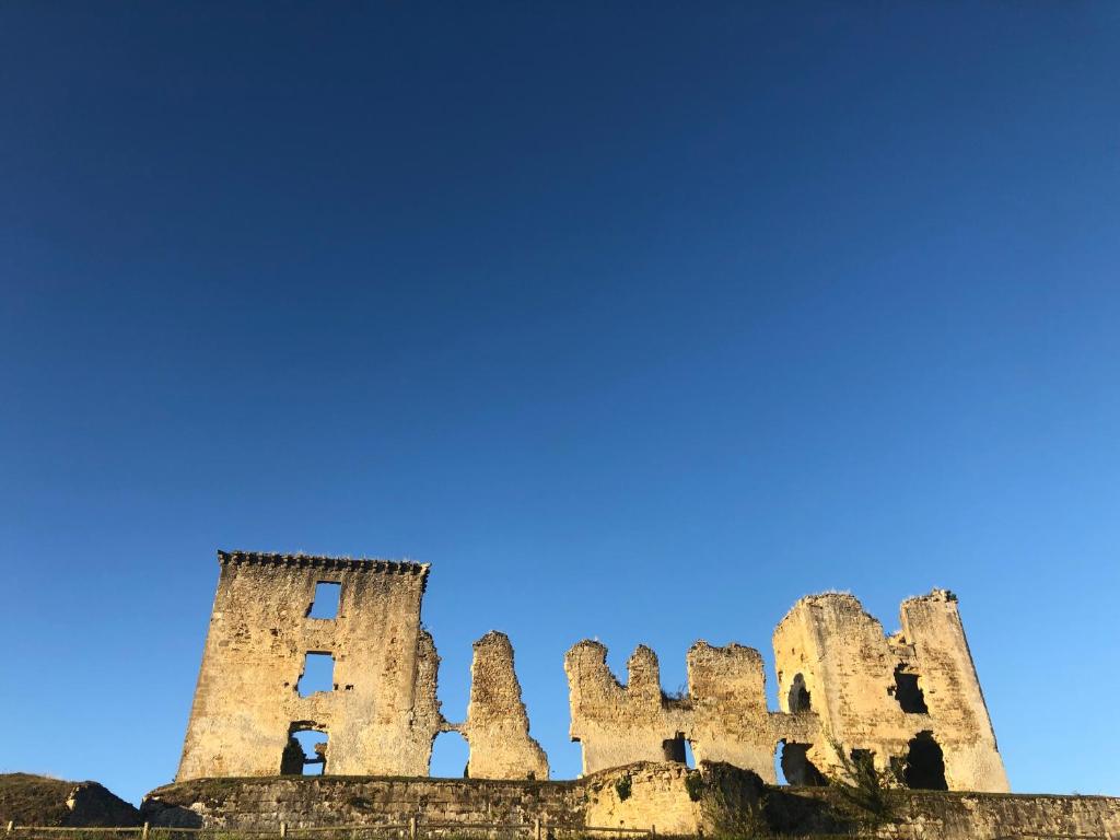 an old castle with a blue sky in the background at Maison Marie in Lagarde