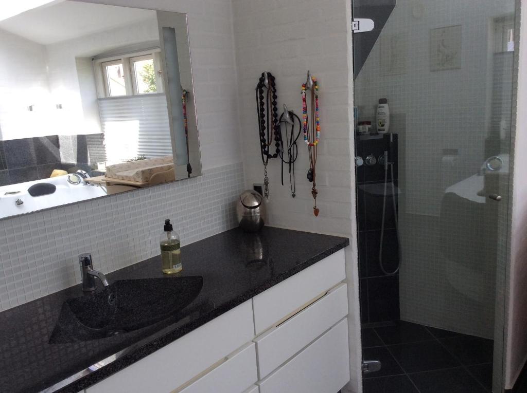 un bagno con lavandino e doccia di Langø Overnatning a Langø