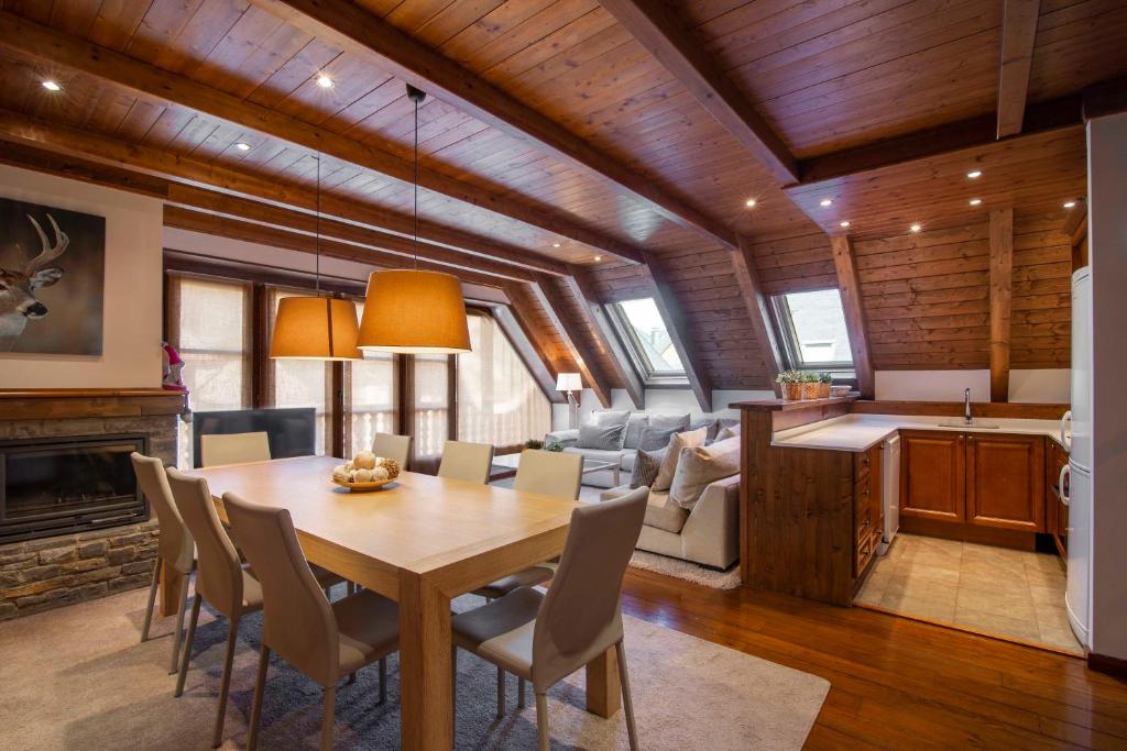 a dining room and living room with a table and chairs at TAMARRO de Alma de Nieve in Baqueira-Beret