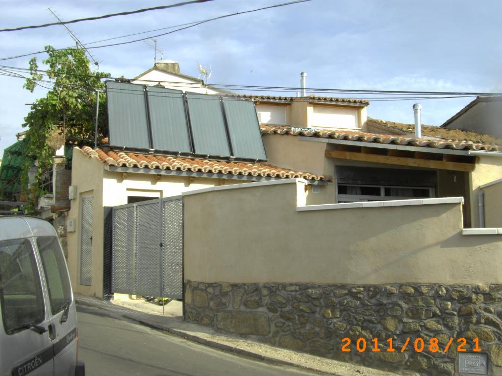 una casa con paneles solares al lado de una calle en LA LOBERA (VALLE DEL TIETAR), en La Iglesuela