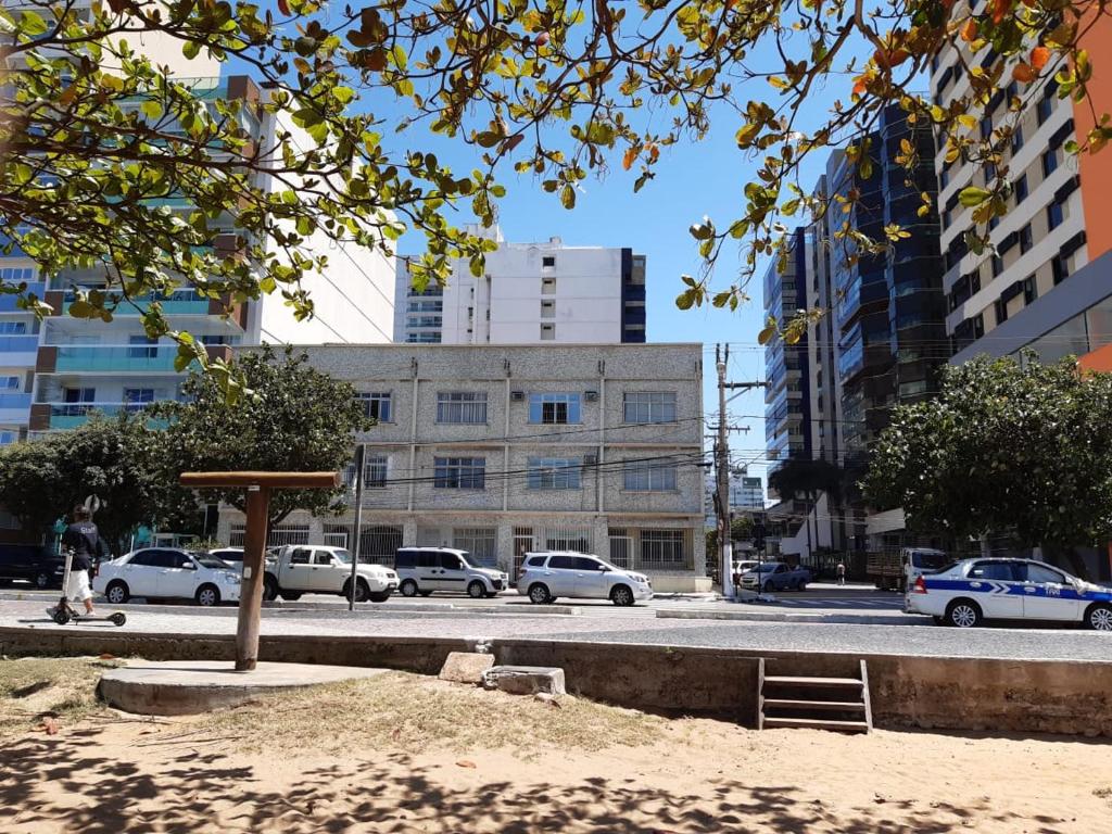 una calle con coches estacionados en una ciudad con edificios en Yellow Hostel Praia da Costa, en Vila Velha