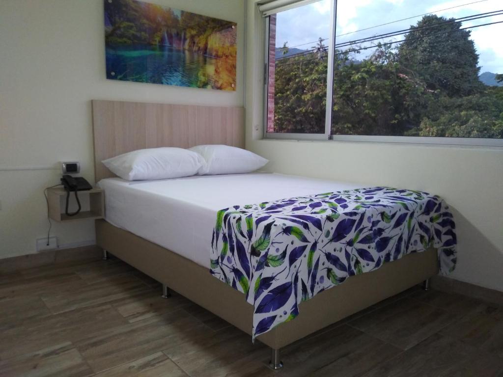 1 dormitorio con cama y ventana en Hotel Street 50 Estadio, en Medellín