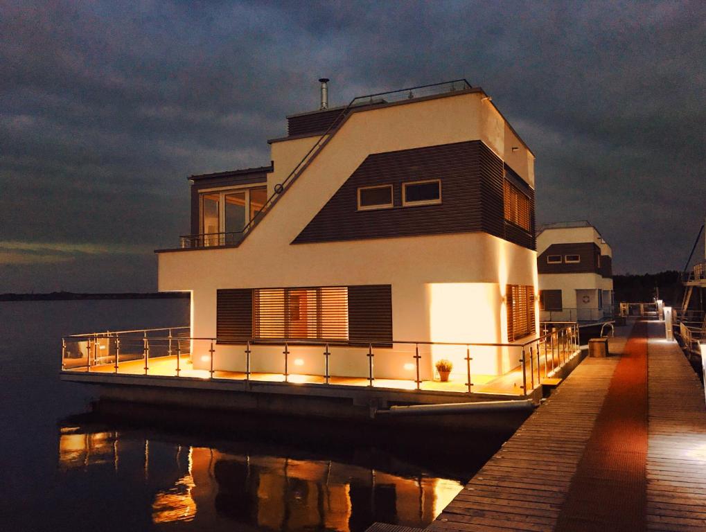 a house on a dock on the water at night at Schwimmendes Haus Robby II in Bitterfeld