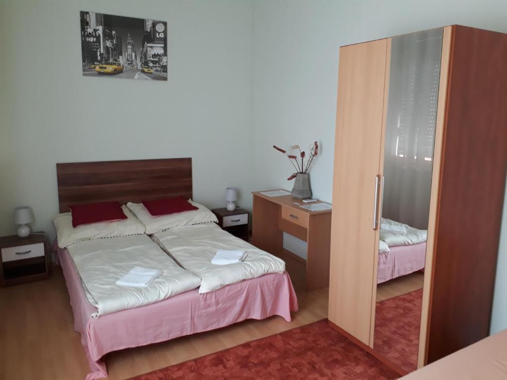 um quarto com uma cama e um espelho em Piac utcai Apartman em Debrecen