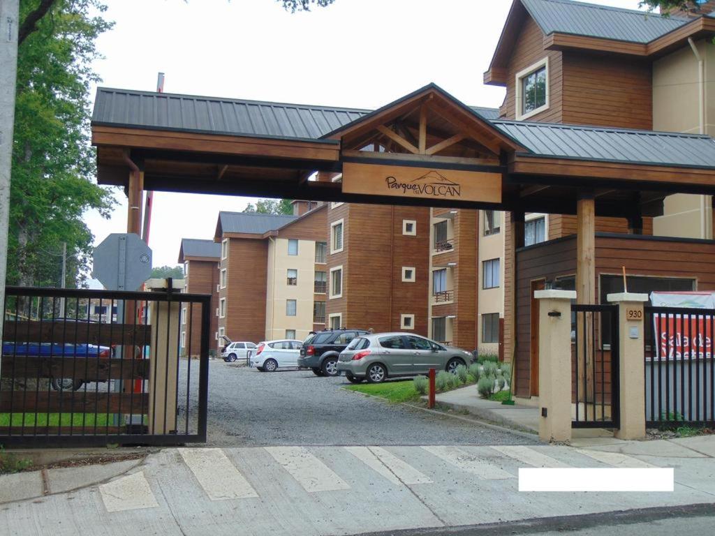 een gebouw met een poort voor een parkeerplaats bij Parque del Volcan Pucon in Pucón